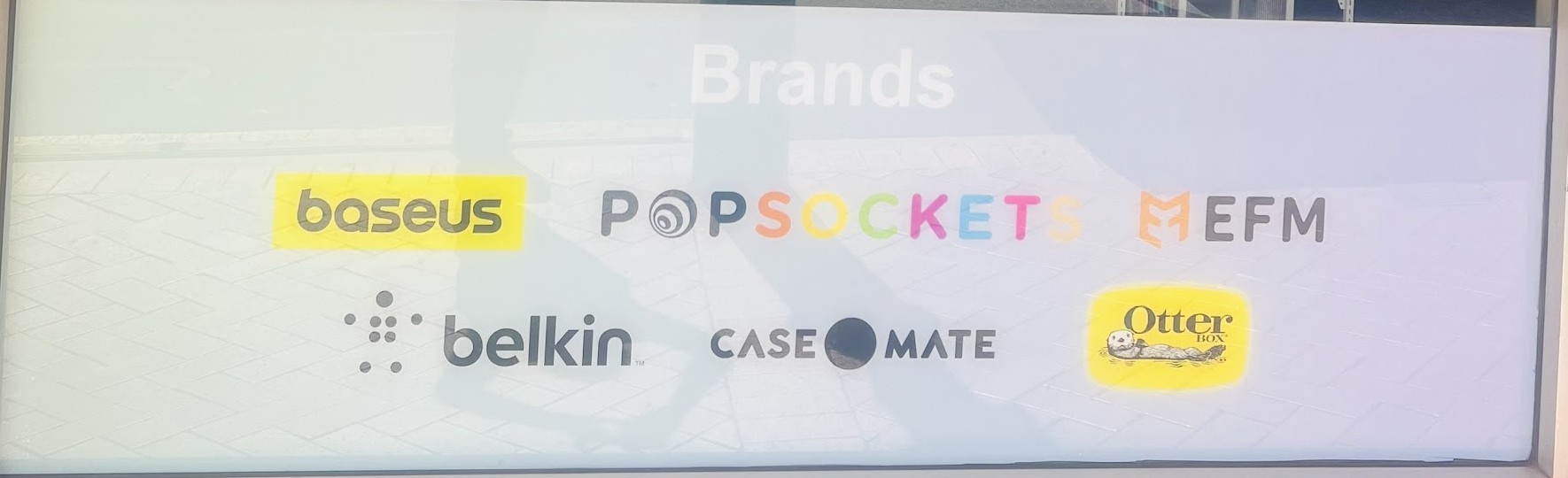 Window decal listing brands stocked: Baseus, PopSockets, EFM, Belkin, Case-Mate and OtterBox