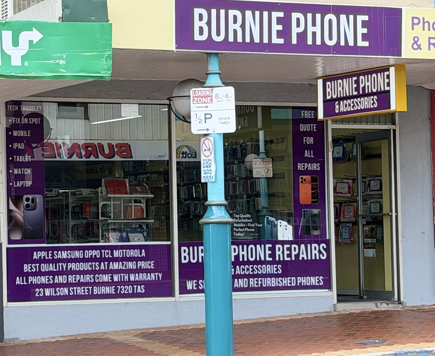 Window signs at Burnie Phone Repairs listing the devices they fix and the brands they service
